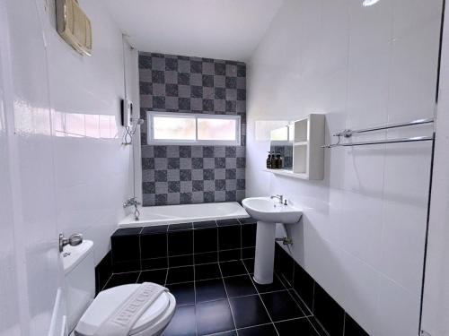 a white bathroom with a sink and a toilet at Sky View Resort Buriram in Buriram