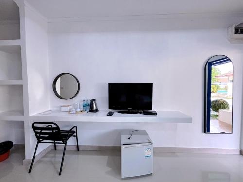a white desk with a television and a chair at Sky View Resort Buriram in Buriram