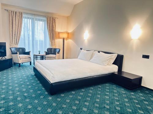 a hotel room with a bed and a desk and chairs at National Golf Resort in Klaipėda