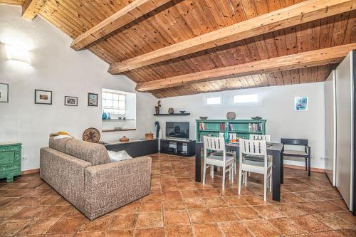 a living room with a couch and a table and chairs at Una Mansarda Nell'isola - Happy Rentals in La Maddalena