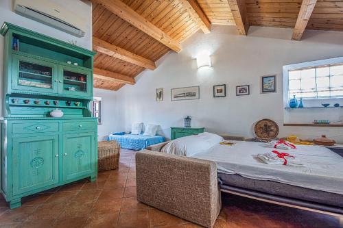 a bedroom with a green cabinet and a bed at Una Mansarda Nell'isola - Happy Rentals in La Maddalena