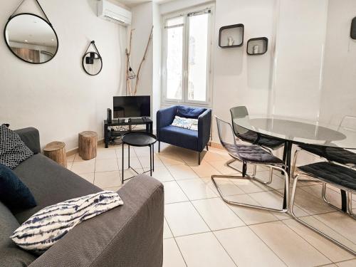 un salon avec un canapé, une table et des chaises dans l'établissement Fontaine 4 Pers AC WiFi, à Nice