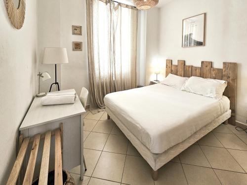 une chambre avec un grand lit blanc et un bureau dans l'établissement Fontaine 4 Pers AC WiFi, à Nice