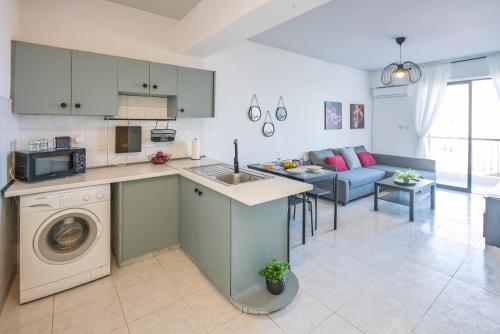 a kitchen and living room with a washing machine at Seaview Anteia's Central Finikoudes Apt in Larnaca in Larnaka