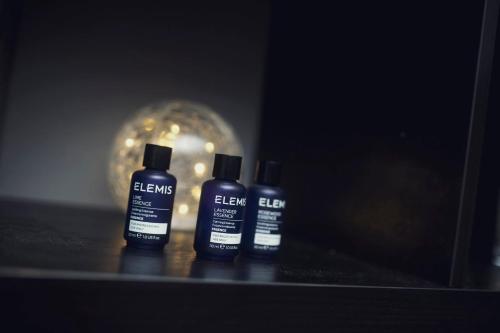 three bottles of black cleaner sitting on a table with a ball at Holiday Inn Newcastle Gosforth Park by IHG in Newcastle upon Tyne