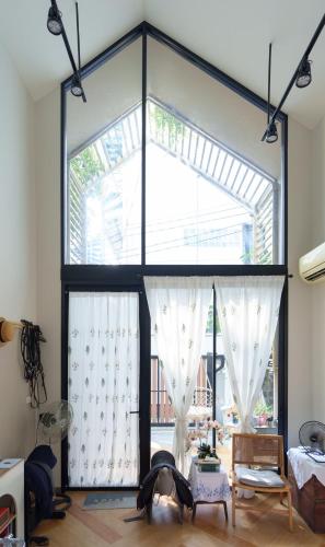 a room with a large window with white curtains at hiddenmoon cottage in Bangkok
