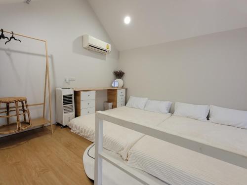 una camera bianca con letto e cassettiera di hiddenmoon cottage a Bangkok