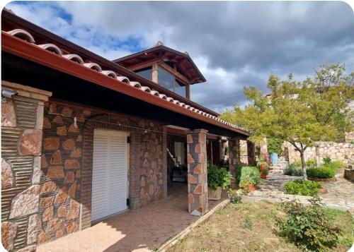 ein Steinhaus mit einer Garage im Hof in der Unterkunft Stones Villa in Sarandë