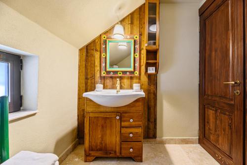 a bathroom with a sink and a mirror at Casa cu Amintiri - Authentic Cozy Cottage in Bran