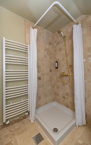 a shower with a shower curtain in a bathroom at Casa cu Amintiri - Authentic Cozy Cottage in Bran
