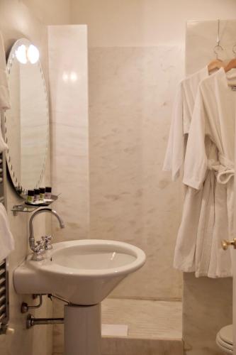 a white bathroom with a sink and a mirror at Palazzo Contarini Della Porta Di Ferro in Venice