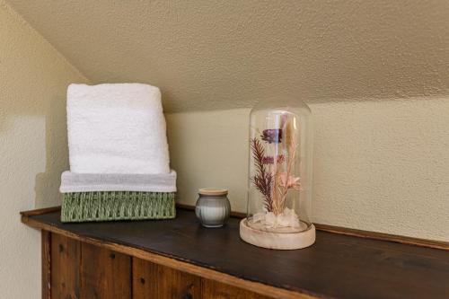 a shelf with a glass vase and towels on it at Casa cu Amintiri - Authentic Cozy Cottage in Bran