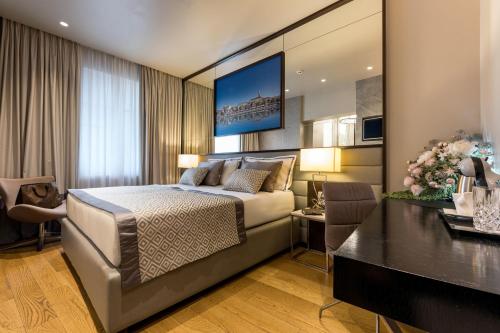 a bedroom with a bed and a living room at Fortuna Luxury Rooms 1 in Split