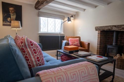 a living room with a blue couch and a fireplace at Peckforton cottage totally refurbished in Beeston