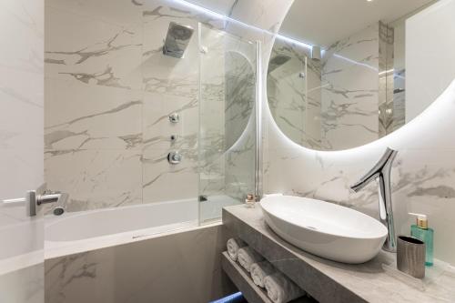 a white bathroom with a sink and a shower at Fortuna Luxury Rooms 1 in Split