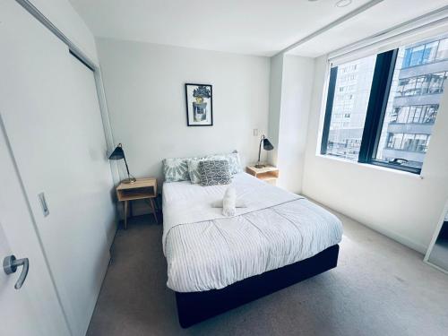 a small bedroom with a bed and a window at Apartment in Auckland City in Front of Sky Tower in Auckland