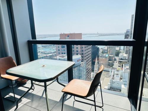 a table and chairs on the balcony of a building at Apartment in Auckland City in Front of Sky Tower in Auckland