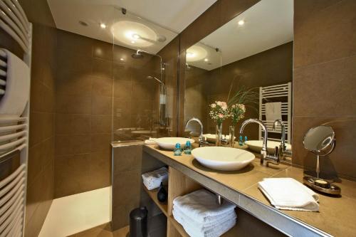 a bathroom with two sinks and a large mirror at Les Jardins du Porche in Sarlat-la-Canéda