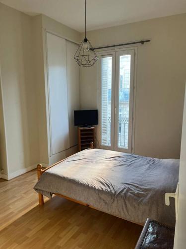 une chambre avec un lit et une télévision dans l'établissement Deniz, à Bordeaux