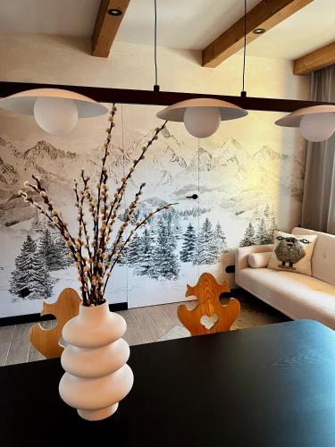 a white vase with flowers in a living room at Sleep & Sheep in Kościelisko