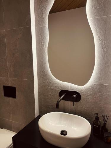 a bathroom with a white sink and a mirror at Sleep & Sheep in Kościelisko