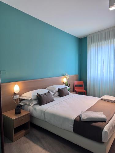 a bedroom with a large bed and a blue light at Hotel La Magione in Poggibonsi
