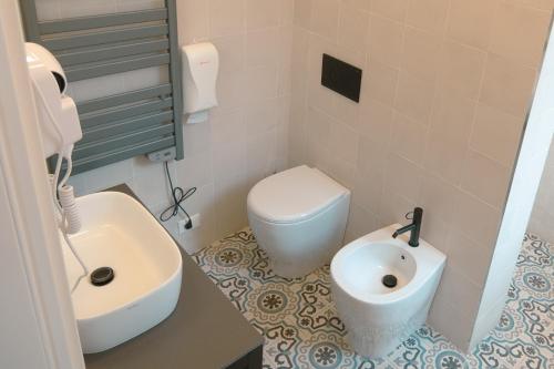 a bathroom with a white toilet and a sink at Casali Hostel in Trieste