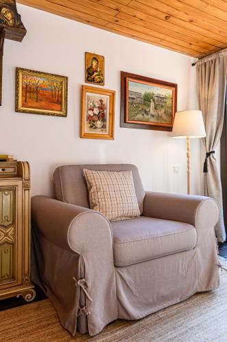 a living room with a couch and paintings on the wall at Casa cu Amintiri - Authentic Cozy Cottage in Bran