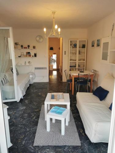 un salon avec un canapé et une table dans l'établissement Juan-les-Pins, superbe studio vue mer grande Terrace cuisine séparée, à Antibes