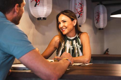 a man shaking hands with a woman at a table at Hotel Magic Sports 4 in Oropesa del Mar