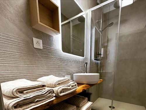 La salle de bains est pourvue d'un lavabo, d'une douche et de serviettes. dans l'établissement Le 45- La Sauvagine, Appartement avec grande terrasse, 6 Couchages, 2 chambres, 3min de la plage, à Saintes-Maries-de-la-Mer