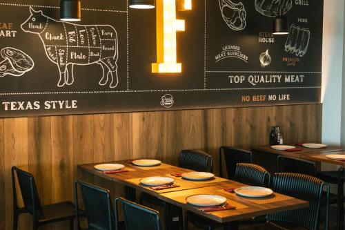 a dining room with tables and chairs and a chalkboard at Hotel Magic Sports 4 in Oropesa del Mar
