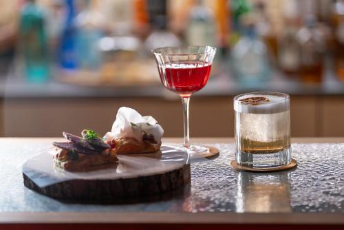 a plate of food and a glass of wine on a table at Hammerack Hotel, SPA & Wellness in Malborghetto Valbruna