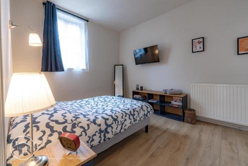 a bedroom with a bed and a table with a lamp at Les vieilles tours Bellevue Parking in Chambéry