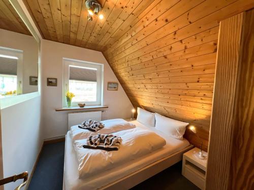zwei Betten in einem Zimmer mit Holzdecke in der Unterkunft Elke in Tinnum