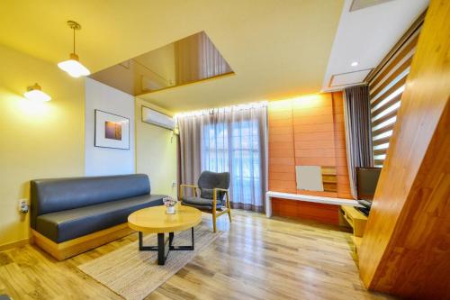 a living room with a couch and a table at Tongyoung Mongdolhouse Pension in Tongyeong
