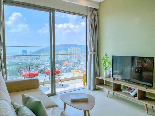 a living room with a tv and a large window at Erica's House - Oceanview The Sóng Apartment Vũng Tàu Nghỉ Dưỡng Biển Cao Cấp 5 Sao - The Song Vung Tau Condotel 5 Star Beach View Apartment in Vung Tau