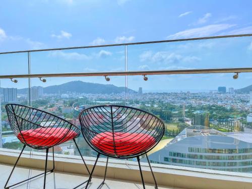 two red chairs sitting on top of a window at Erica's House - Oceanview The Sóng Apartment Vũng Tàu Nghỉ Dưỡng Biển Cao Cấp 5 Sao - The Song Vung Tau Condotel 5 Star Beach View Apartment in Vung Tau