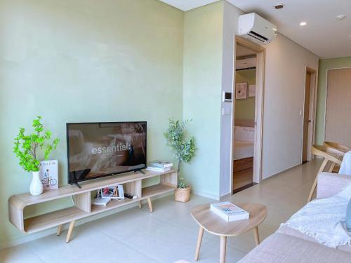 a living room with a flat screen tv sitting on a cabinet at Erica's House - Oceanview The Sóng Apartment Vũng Tàu Nghỉ Dưỡng Biển Cao Cấp 5 Sao - The Song Vung Tau Condotel 5 Star Beach View Apartment in Vung Tau