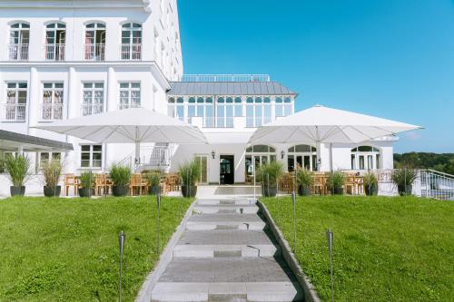 dos sombrillas blancas frente a un edificio en Precise Resort Schwielowsee - Hotel, en Werder
