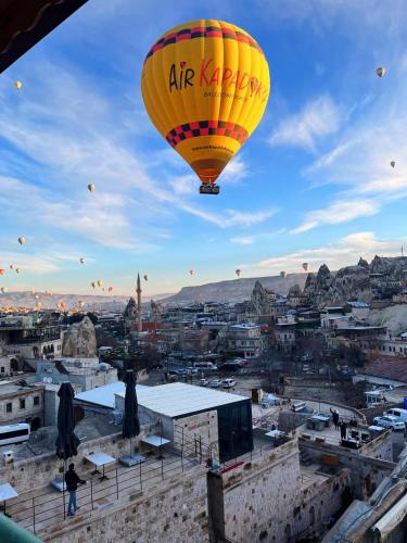 a yellow hot air balloon flying over a city at Gedik Cave Hotel in Goreme