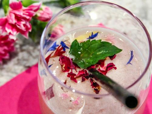 a drink with a green leaf on top of it at City Hotel Merano in Merano