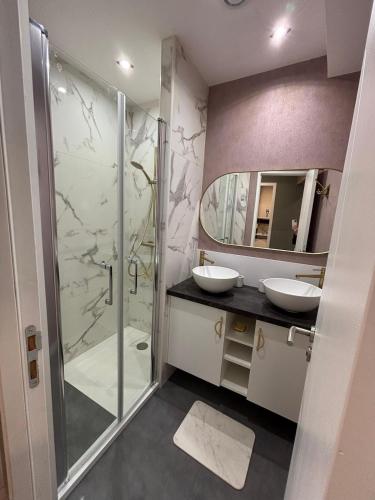 une salle de bain avec deux lavabos et une douche dans l'établissement Magnifique appartement neuf 4 chambres, à Luchon