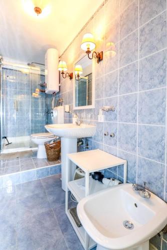 a bathroom with two sinks and a toilet and a tub at Villa Augusta Ferri in Rovinj