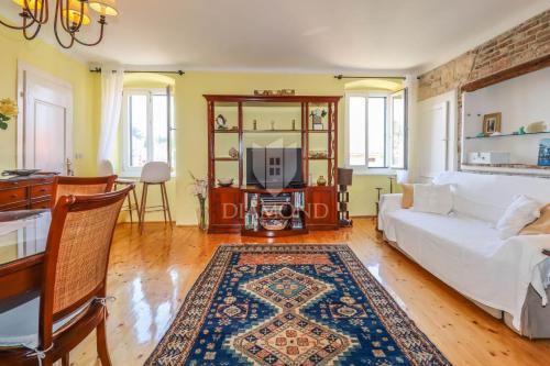 a living room with a white couch and a tv at Villa Augusta Ferri in Rovinj