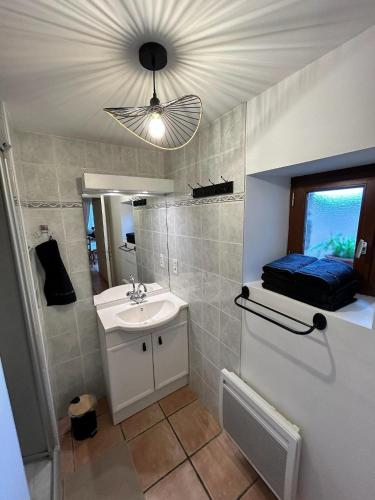 une salle de bain avec un lavabo et un miroir dans l'établissement La maison du malteur vue mer, à Plurien