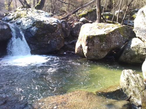 a stream of water with rocks and a waterfall at l 'appel du Canigou in Casteil