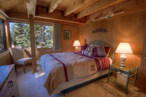 a bedroom with a bed and a chair and a window at Chimney Rock Condo condo in Stateline