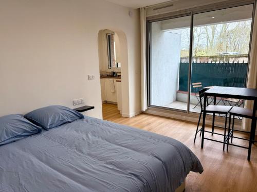 une chambre avec un lit, une table et une fenêtre dans l'établissement Charmant studio au cœur de Toulouse, à Toulouse