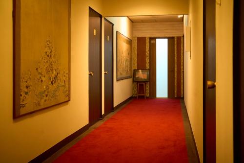 a hallway with a red carpet and two doors at 美術の宿 箱根もみじの森 in Hakone